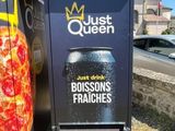 une boîte aux lettres sur laquelle est posée une pizza, à côté d'une poubelle