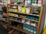 a shelf full of paint and other paints in a room