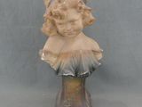 une petite statue représentant une femme coiffée d'un chapeau
