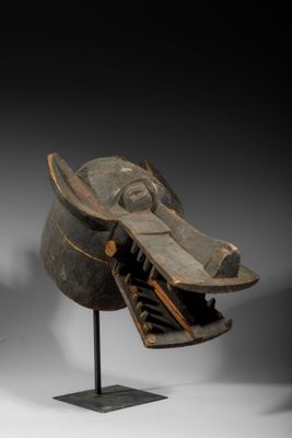 une photo d'une sculpture en bois représentant une tête de chien posée sur un socle