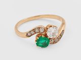 un gros plan d'une bague en or sertie d'une émeraude verte et de diamants blancs