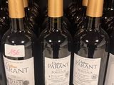 several bottles of wine are lined up on a shelf in a store