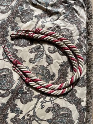 a red and white rope that is laying on a blanket