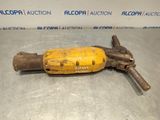 a close up of a yellow drill on a metal surface