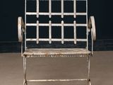 a white metal chair that is sitting in a room