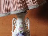 a lamp that is on a table with a pink shade on it