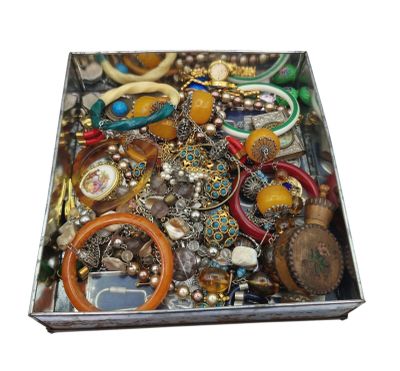 a metal box filled with lots of assorted jewelry
