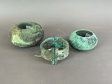 three pieces of green pottery sitting on top of a table