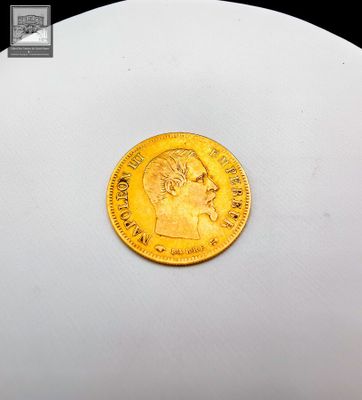 gros plan d'une pièce d'or sur une surface blanche