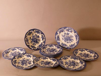 blue and white plates and bowls on a table with a brown background