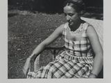 photographie en noir et blanc d'une femme assise sur un banc dans un parc