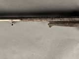 an old rifle with a wooden barrel on a white background