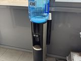 a water dispenser on the floor next to a window