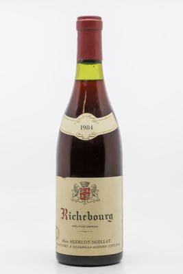une bouteille de vin rouge avec une étiquette blanche posée sur une surface blanche