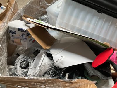 un tas d'objets dans un sac en plastique posé par terre