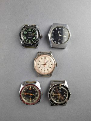 four different types of watches are displayed on a table