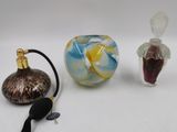 trois petits objets en verre posés sur une surface blanche