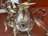un plateau en argent avec une théière en argent et un plateau en argent avec une théière en argent dessus