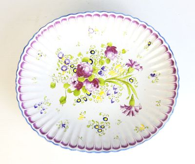 Coupe en faïence à bordure godronnée et décor floral.