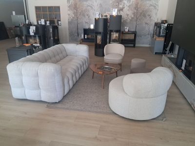 un salon avec un canapé, un fauteuil, une table basse et une télévision