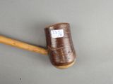 a wooden mallet with a label on it