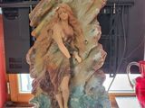 a statue of a woman sitting on a rock on a desk