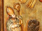 a statue of a man holding a staff in front of a sun