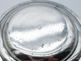 a silver plate with a lid on a white table