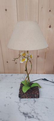 une lampe ornée d'une fleur, posée sur une table