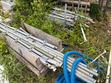 a pile of wood and a blue hose in the grass