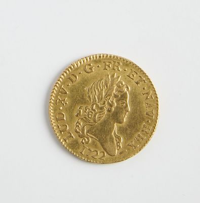 une vieille pièce d'or posée sur une surface blanche
