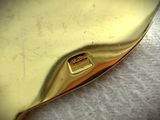 a close up of a gold purse on a white surface