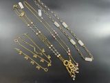 a group of various necklaces and bracelets on a table