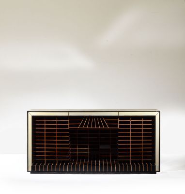 an old radio sitting on top of a white table next to a vase