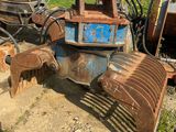 a tractor with a plow attached to it in the dirt