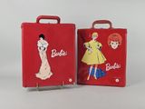 une paire de valises rouges ornées de poupées Barbie, posées côte à côte