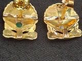 trois bijoux en or posés sur un tissu noir