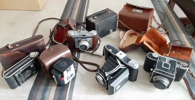 un tas de vieux appareils photo posés sur une table