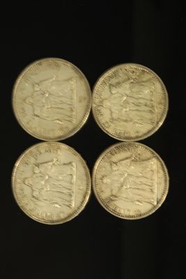 quatre pièces d'argent britanniques posées sur une surface noire