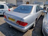 a silver car parked in a parking lot with other cars