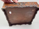 a hand that is putting something in a wooden box