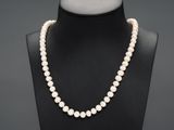 un collier de perles blanches autour du cou d'un mannequin