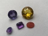a close up of a group of different colored gems on a white surface