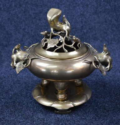 an antique silver plate with a bird sitting on top of it