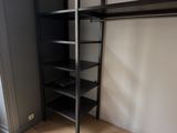 an image of a closet in a bedroom with a book shelf