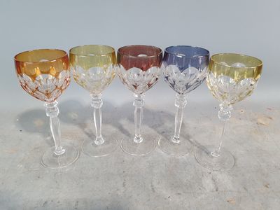 four wine glasses are lined up in a row on a table