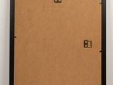 a brown piece of cardboard with a black frame and two brass numbers on it