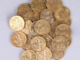 a pile of gold coins sitting on a white surface