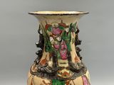 un vase avec un tableau posé sur une table