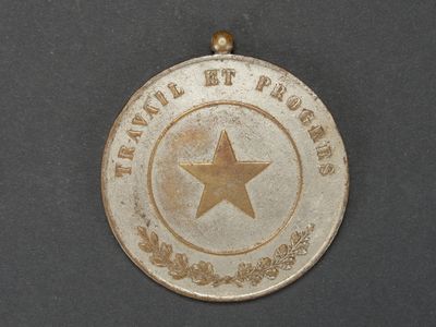 une médaille d'argent ornée d'une étoile, posée sur un fond noir